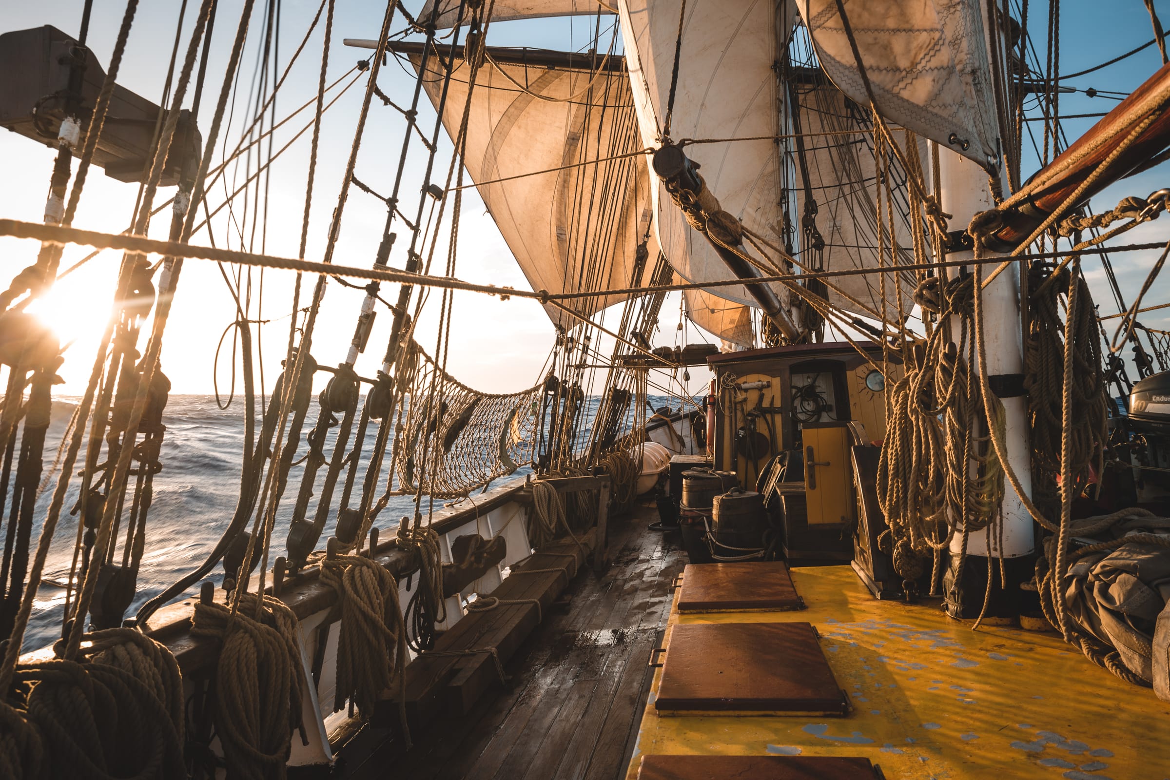 Dek en zeilen van ons schip in het gouden uur
