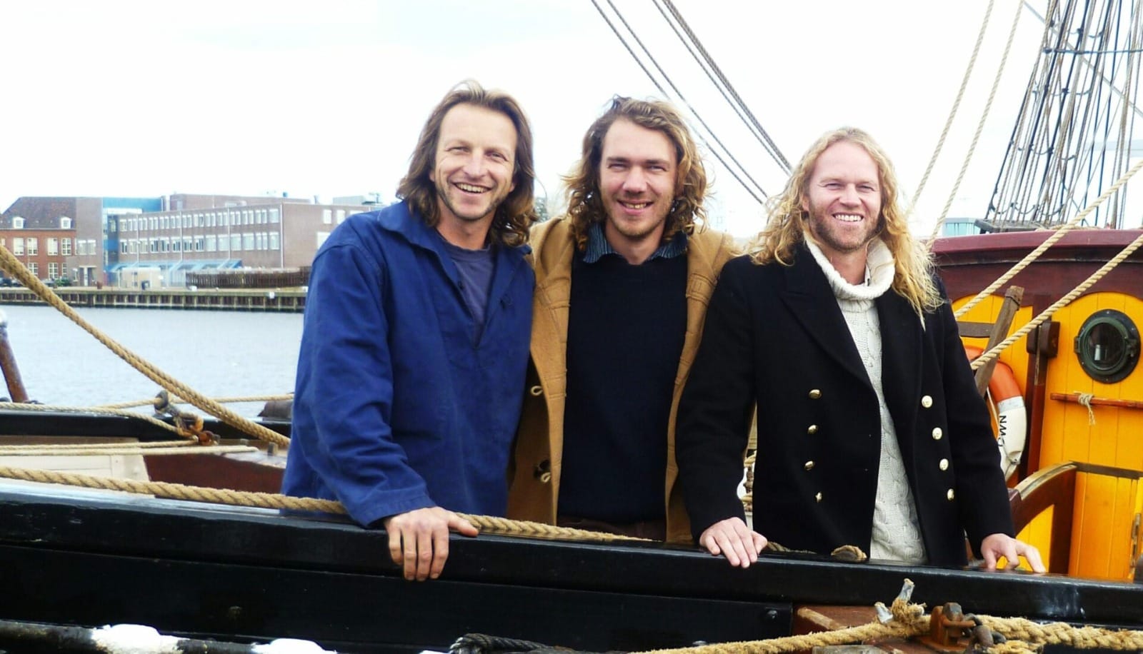 Drie mannen aan de reling van het schip
