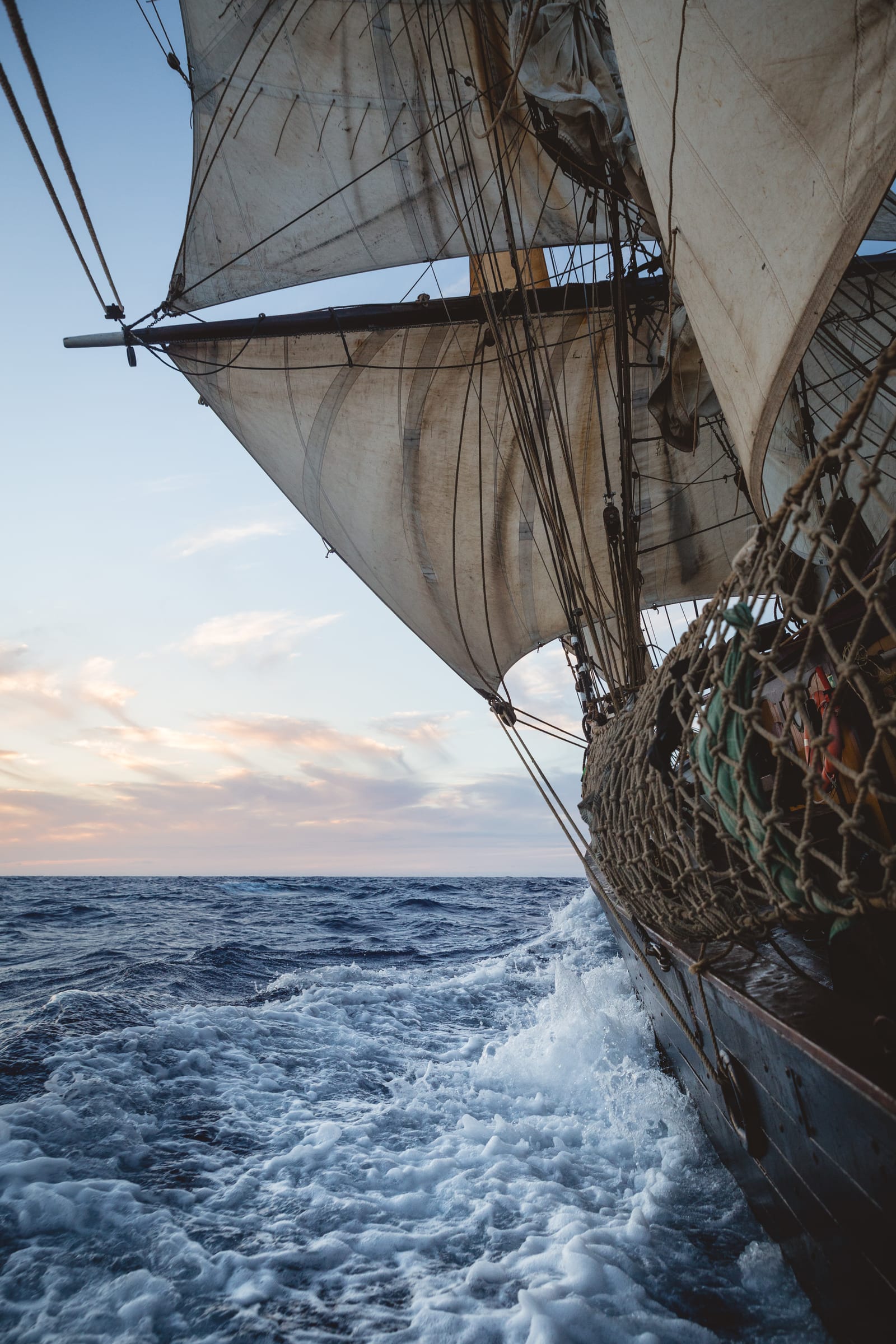 Scheepszij met zeilen en golven in de schemering