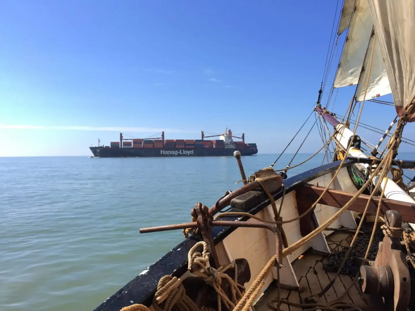 Zicht vanaf de boeg van Tres Hombres op een groot containerschip