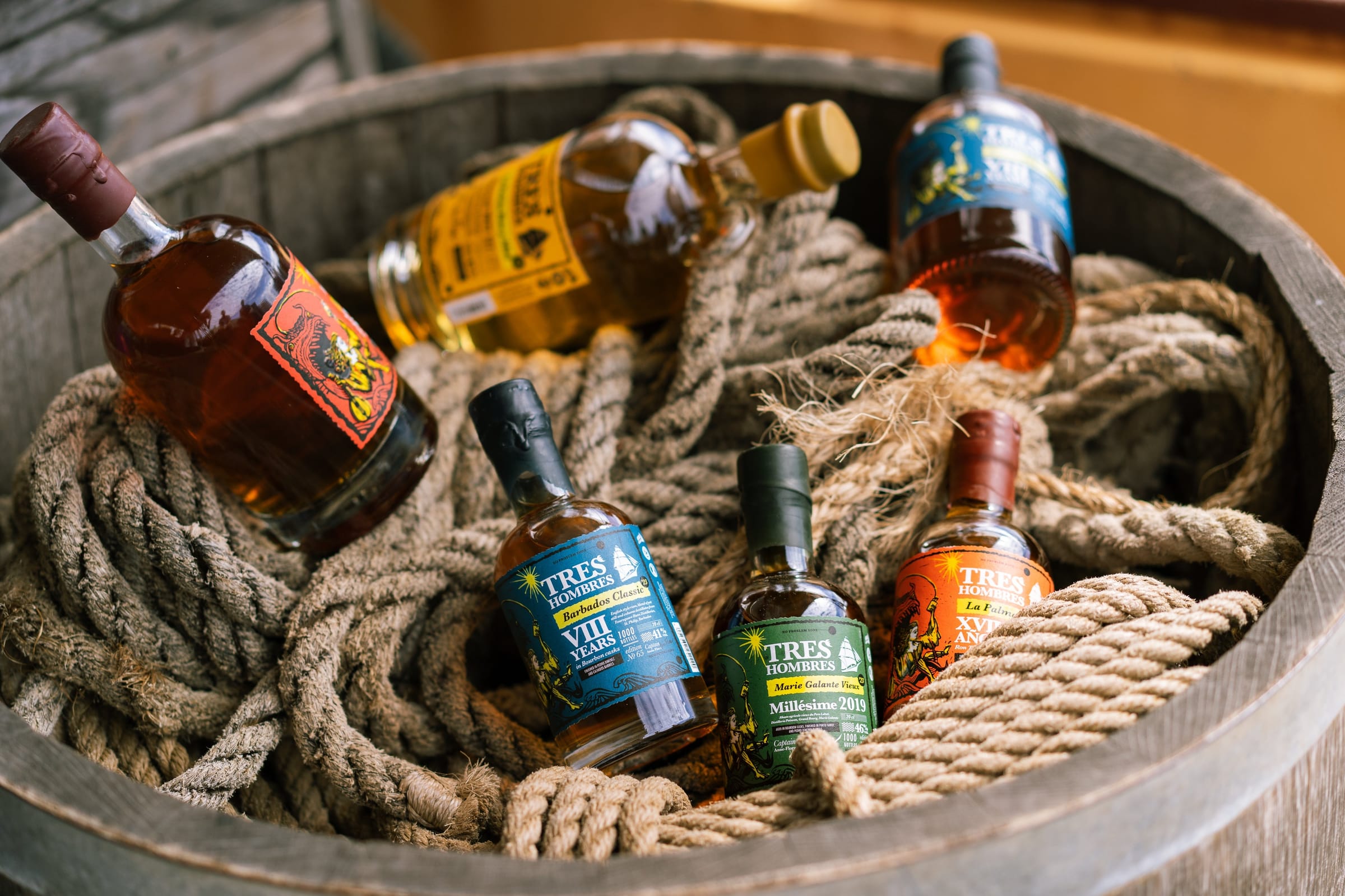 Zes flessen Tres Hombres Rum in een vat met touwen