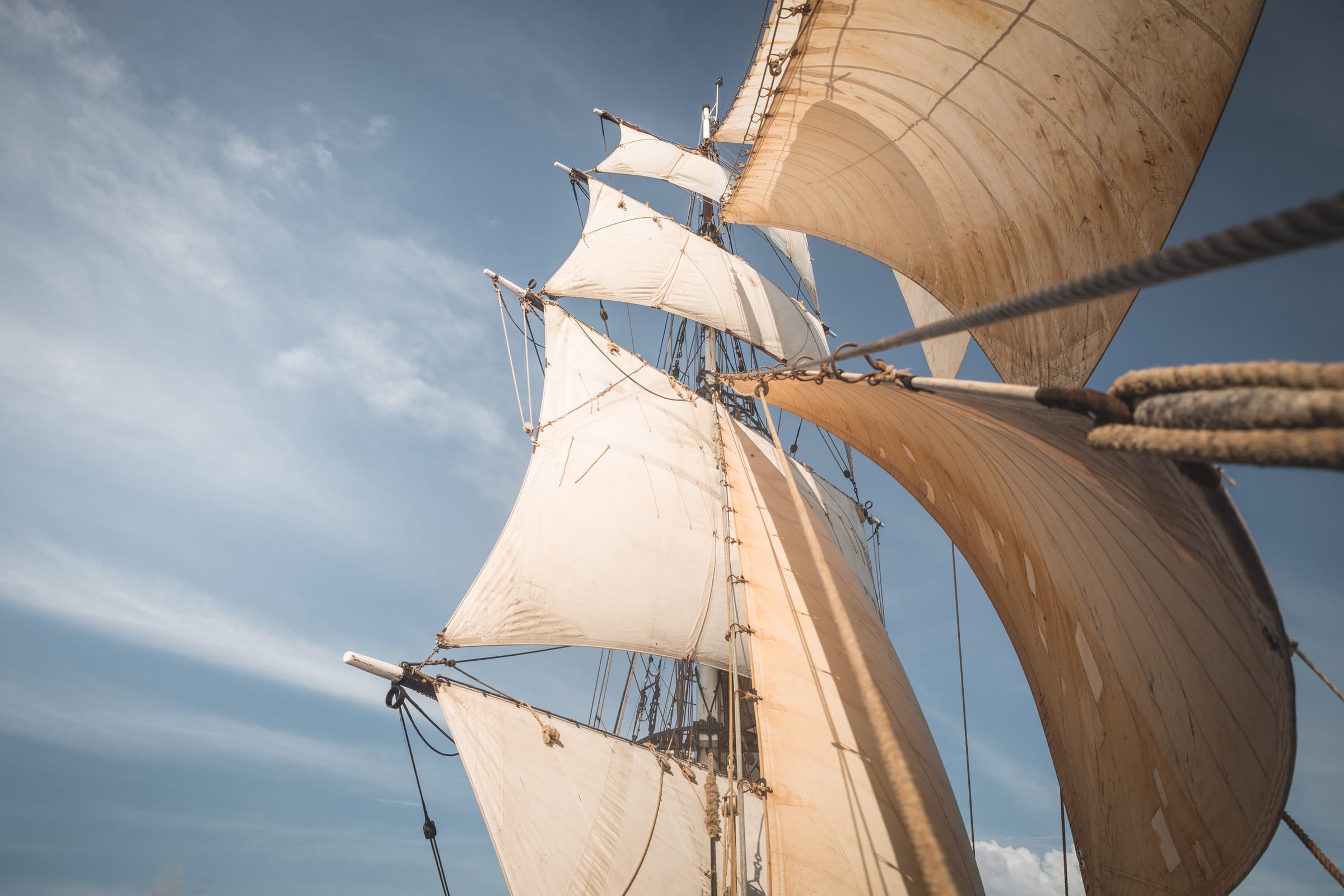 De zeilen van de Tres Hombres van onderaf gezien, tegen een blauwe lucht
